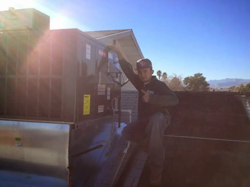 HVAC technician performing Air Duct Repair on a rooftop unit in Gunnison